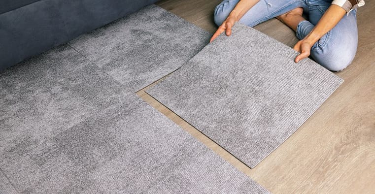 Woman laying carpet tiles