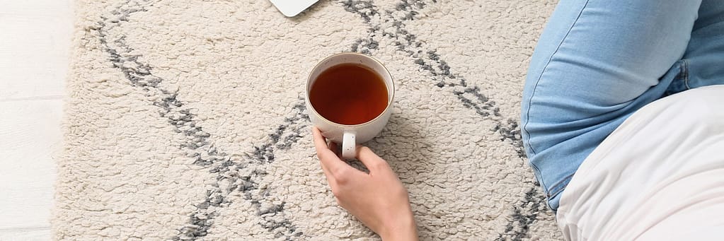 Person sitting on medium pile carpet with a cup of tea