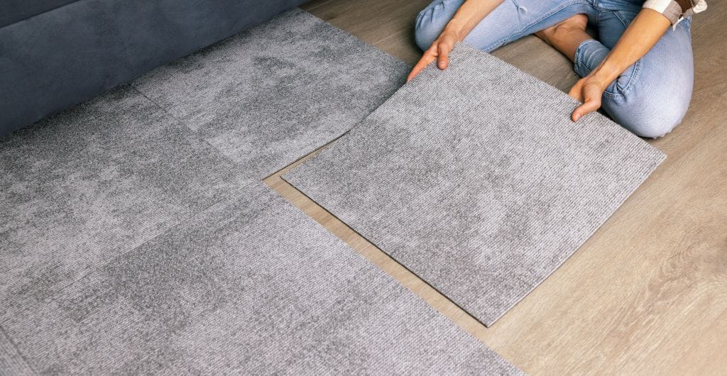 Woman laying carpet tiles